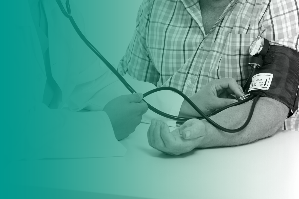 A medical practitioner performs a blood pressure check on a man by using an arm cuff and stethoscope.