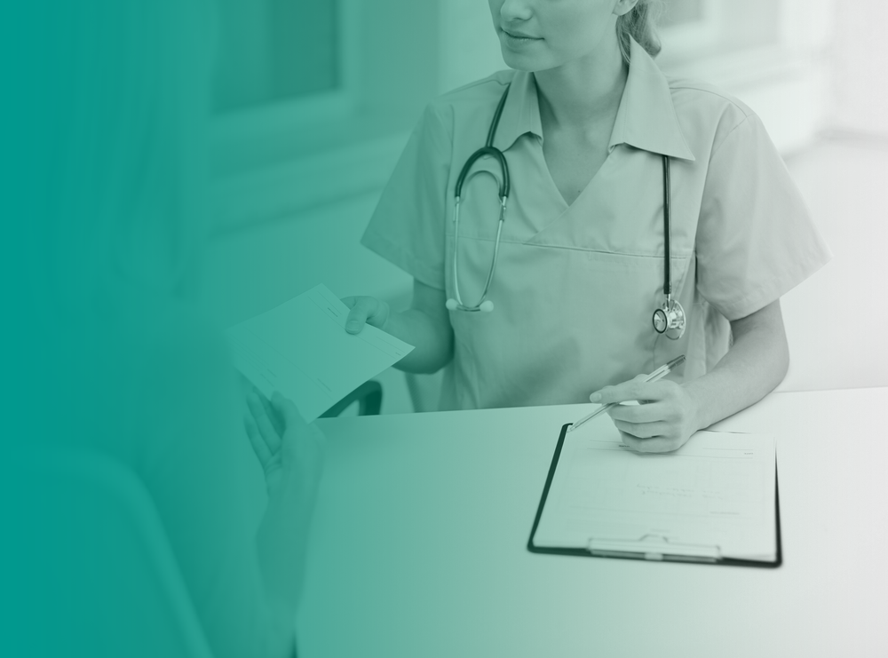 A nurse practitioner wearing a stethoscope around her neck hands a client a sheet of paper that looks like a medical referral.