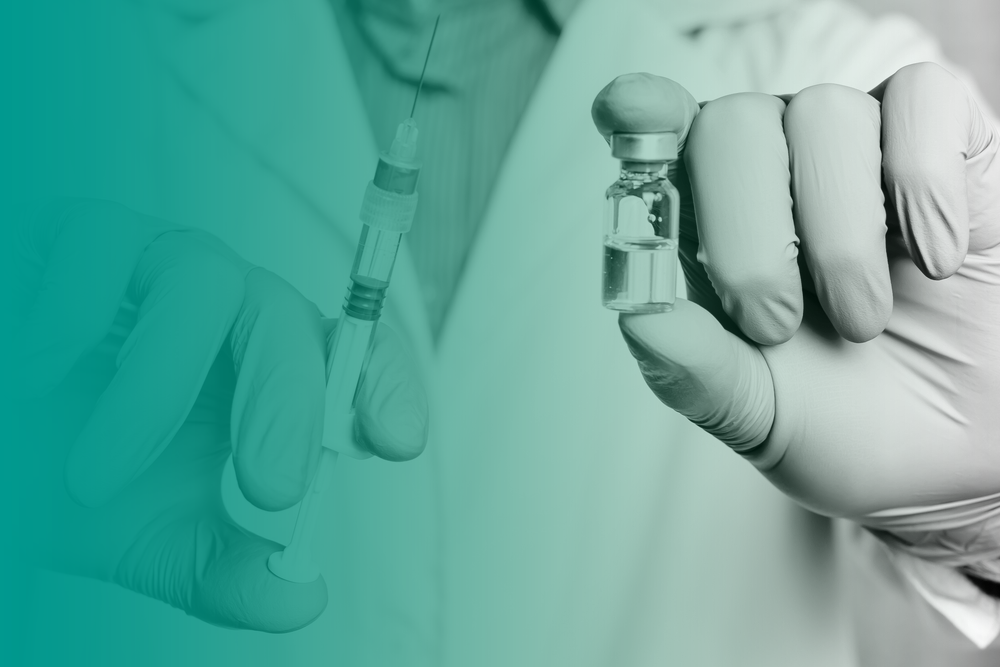 A health care worker holds a small vial and a syringe to add and iron fusion amount.